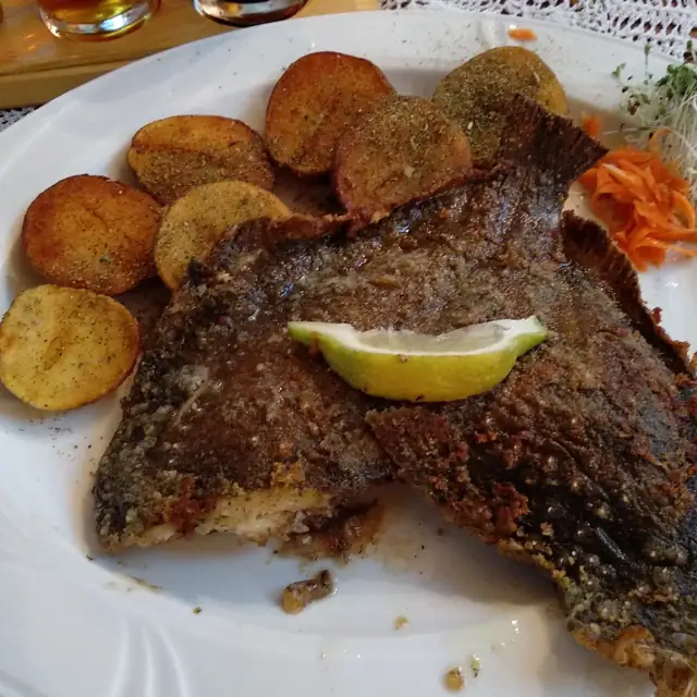 Smażona flądra z opiekanymi ziemniakami i plastrem cytryny