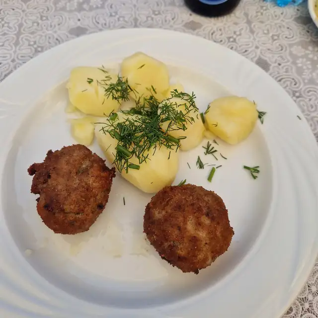 Dwa kotlety mielone z ziemniakami posypanymi koperkiem